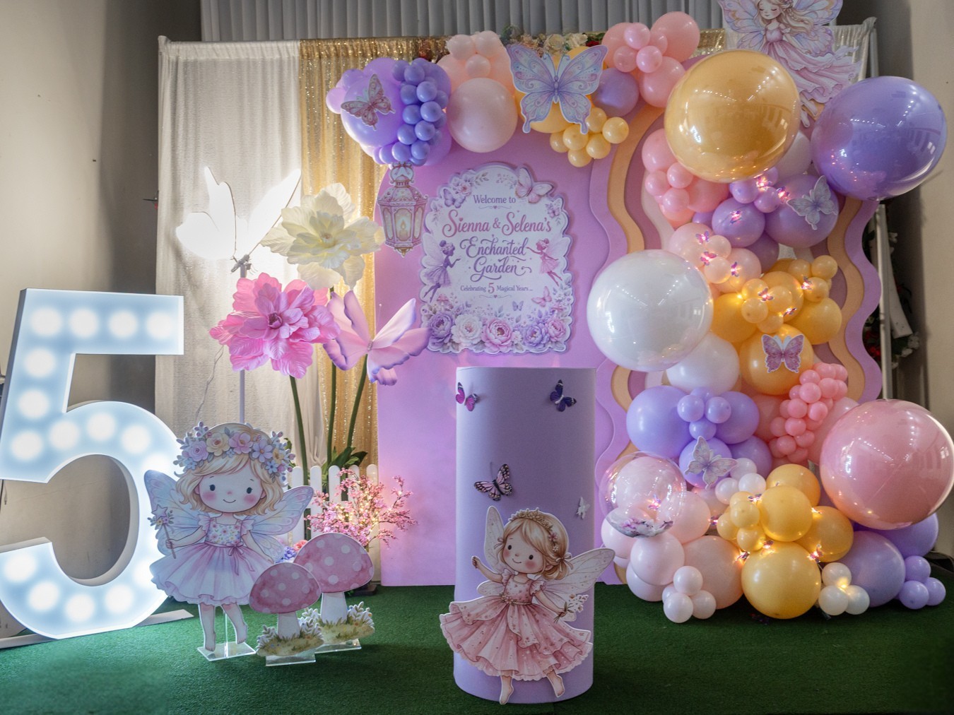Sienna and Selena’s enchanted garden birthday styling, with pastel balloons, fairy cut-outs, flowers and personalised backdrops